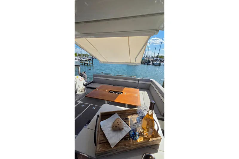 Slide: The Image of 2024 Jeanneau NC Weekender 1295 Fly yacht with elegant deck setup and scenic marina view. - 11
