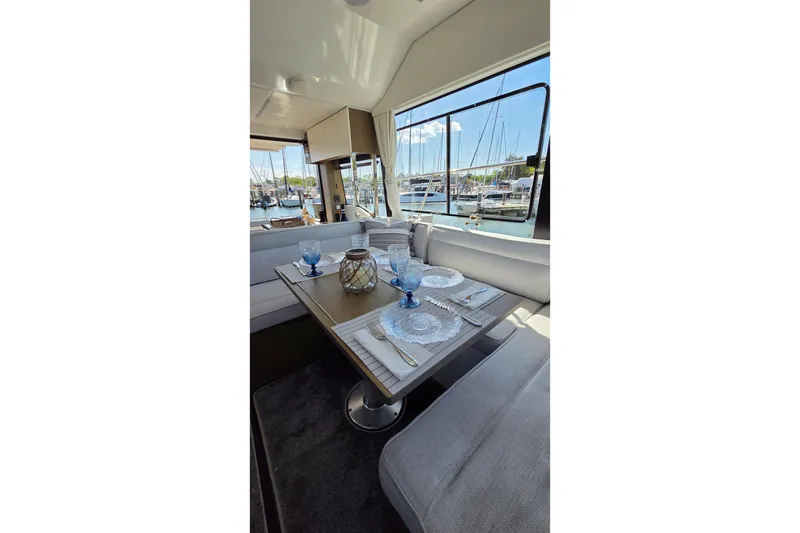 Slide: The Image of Interior of 2024 Jeanneau NC Weekender 1295 Fly with elegant dining setup and marina view. - 15