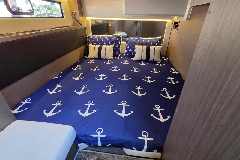 Slide: The Image of Cozy cabin interior of 2024 Jeanneau NC Weekender 1295 Fly with nautical-themed bedding. - 24