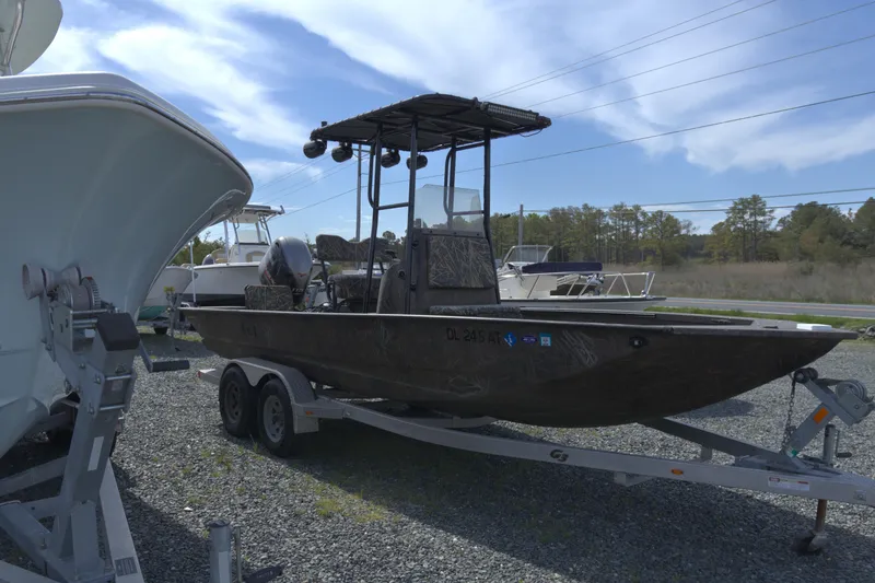 Slide: The Image of 2020 G3 Bay 20 DLX Camo boat on trailer, parked outdoors under blue sky. - 5