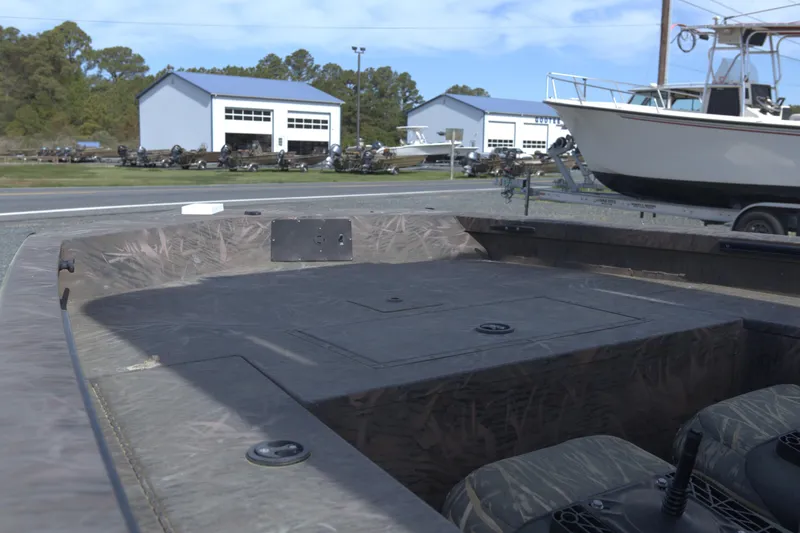 Slide: The Image of 2020 G3 Bay 20 DLX Camo boat with camo interior, parked near a marina. - 8