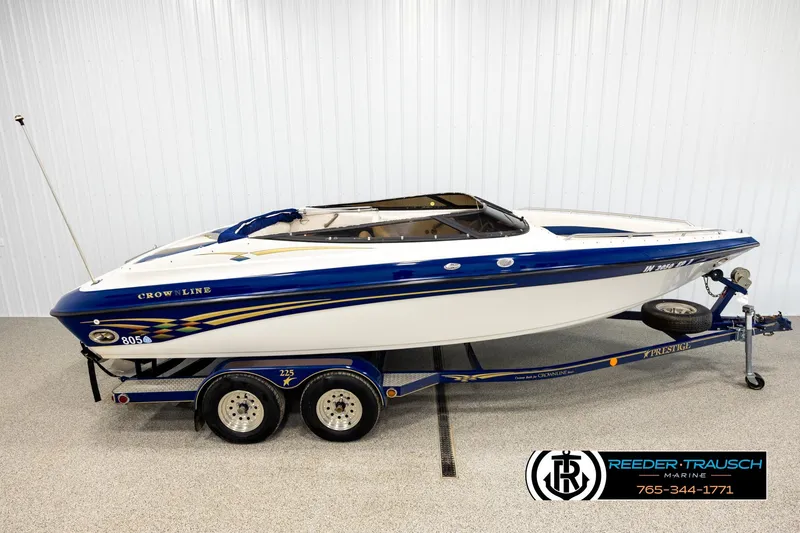 The Image of 2001 Crownline 225 BR boat on trailer in indoor showroom. - 1