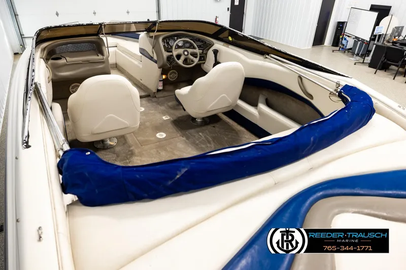 Slide: The Image of 2001 Crownline 225 BR boat interior with white seating and blue accents in showroom. - 11