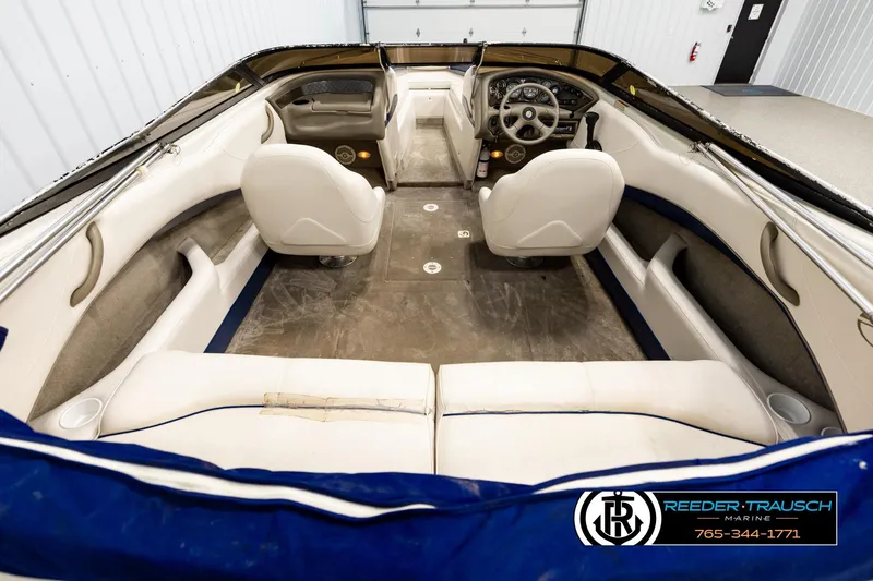 Slide: The Image of Interior view of a 2001 Crownline 225 BR boat with white seating and dashboard. - 13