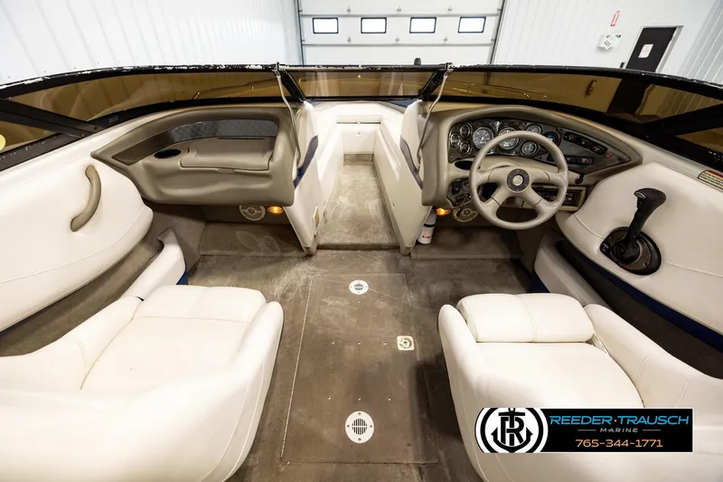 Slide: The Image of Interior of a 2001 Crownline 225 BR boat with beige seating and dashboard. - 14