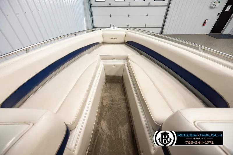 Slide: The Image of 2001 Crownline 225 BR boat interior with white and blue seating in a showroom. - 15
