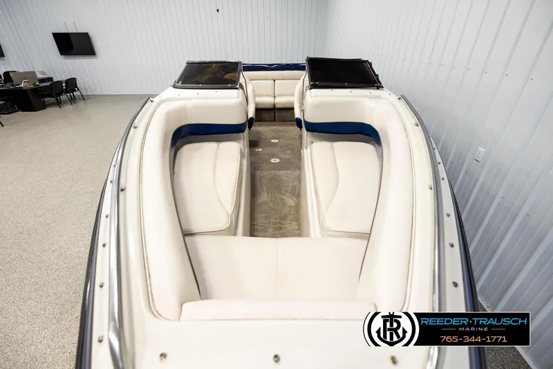 Slide: The Image of 2001 Crownline 225 BR boat interior with white seating in showroom. - 16