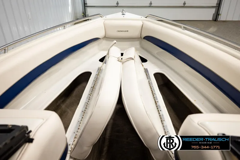 Slide: The Image of 2001 Crownline 225 BR boat interior with white and blue seating, showcased in a garage. - 25