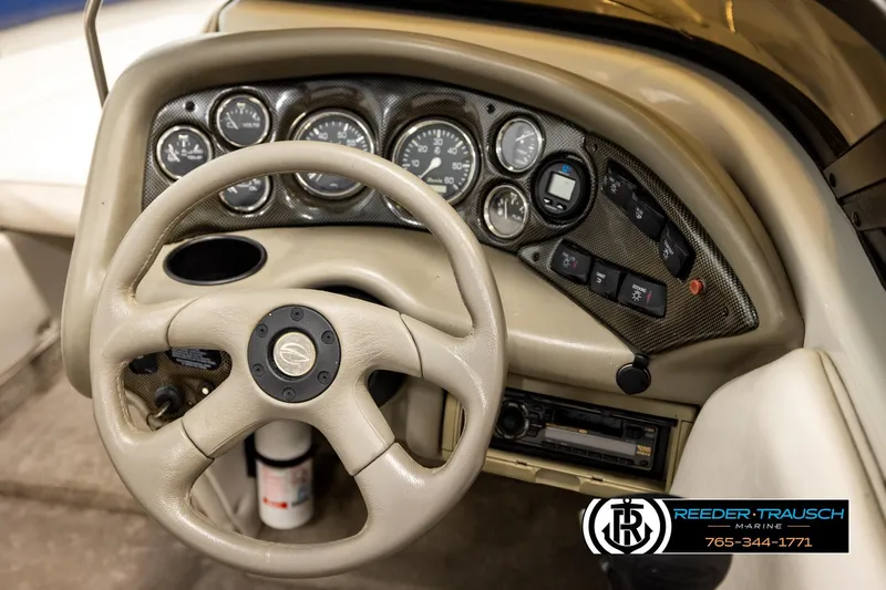 Slide: The Image of Steering wheel and dashboard of a 2001 Crownline 225 BR boat, featuring gauges and controls. - 27