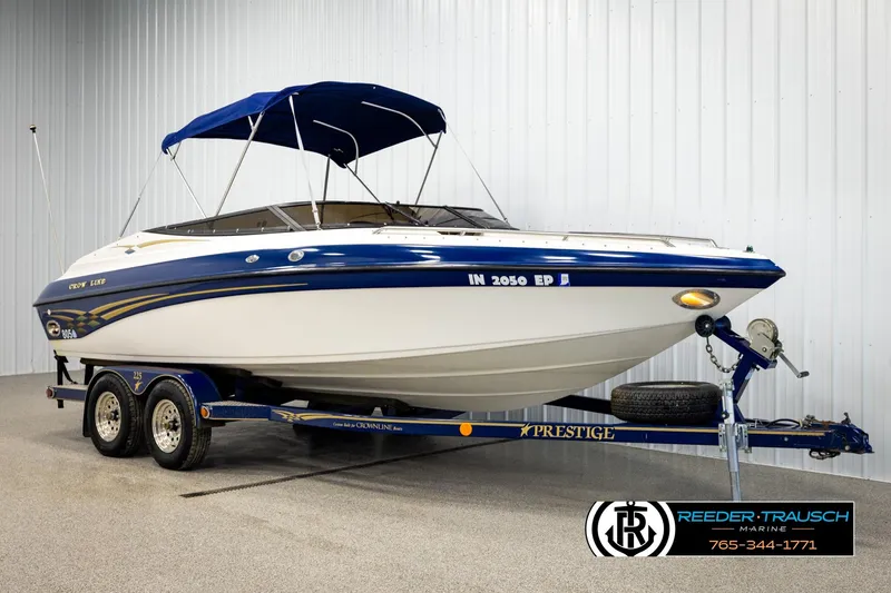 Slide: The Image of 2001 Crownline 225 BR boat on trailer with blue canopy in showroom. - 3