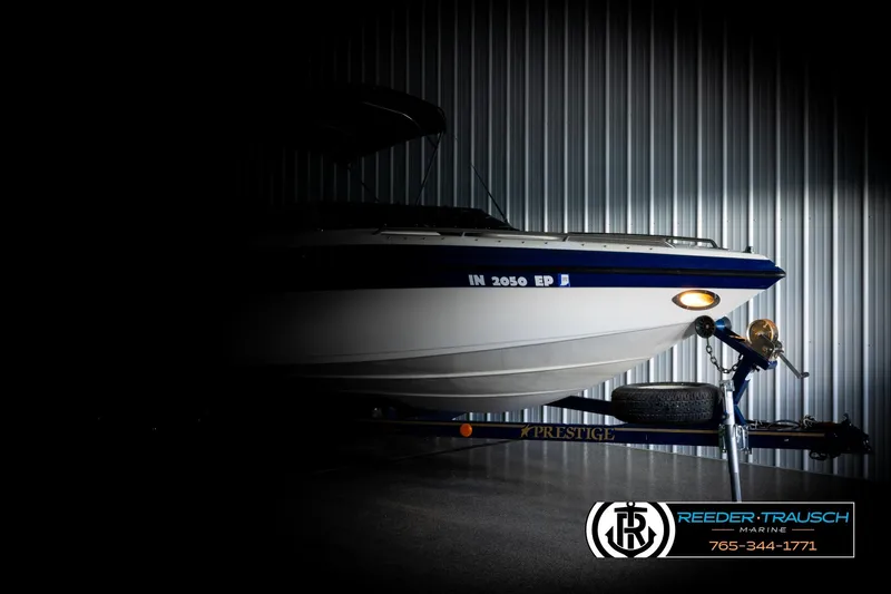 Slide: The Image of 2001 Crownline 225 BR boat on trailer in dimly lit storage facility. - 4