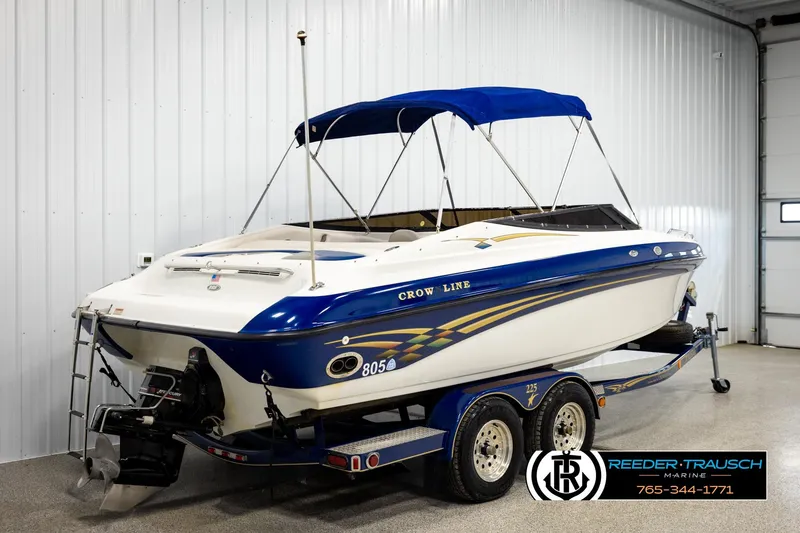 Slide: The Image of 2001 Crownline 225 BR boat with blue canopy on trailer in indoor storage. - 6