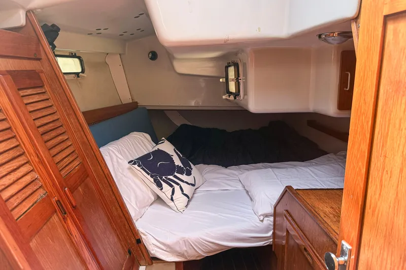 Slide: The Image of Cozy cabin interior of a 1988 Oday 40 sailboat with wooden accents and bedding. - 18