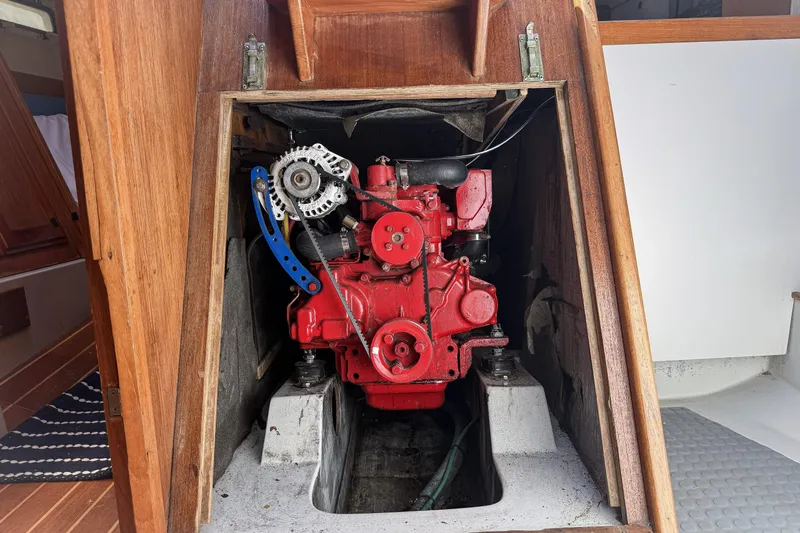 Slide: The Image of Engine compartment of a 1988 Oday 40 sailboat, featuring a red engine. - 19