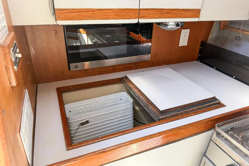 Slide: The Image of 1988 Oday 40 yacht kitchen with microwave and storage compartments. - 22