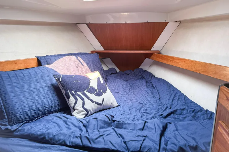 Slide: The Image of Cozy cabin interior of 1988 Oday 40 sailboat with blue bedding and decorative pillow. - 24