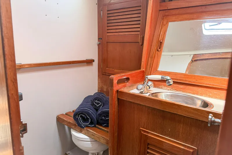 Slide: The Image of 1988 Oday 40 yacht bathroom with wooden cabinetry, sink, and rolled towels. - 26