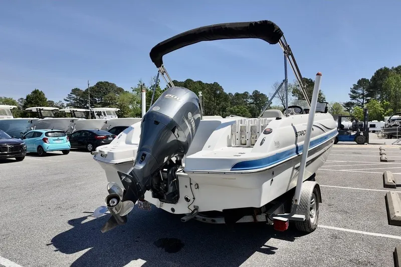 Slide: The Image of 2016 Starcraft 2000 Sportstar boat on trailer in parking lot, featuring outboard motor. - 5