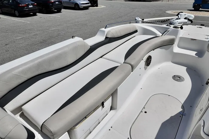 Slide: The Image of 2016 Starcraft 2000 Sportstar boat interior with cushioned seating in a parking lot. - 8