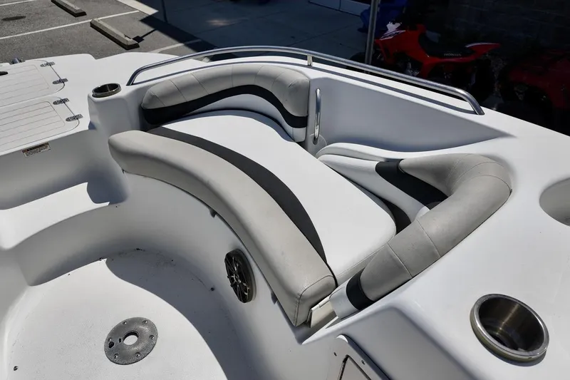 Slide: The Image of 2016 Starcraft 2000 Sportstar boat interior with cushioned seating and cup holders. - 9
