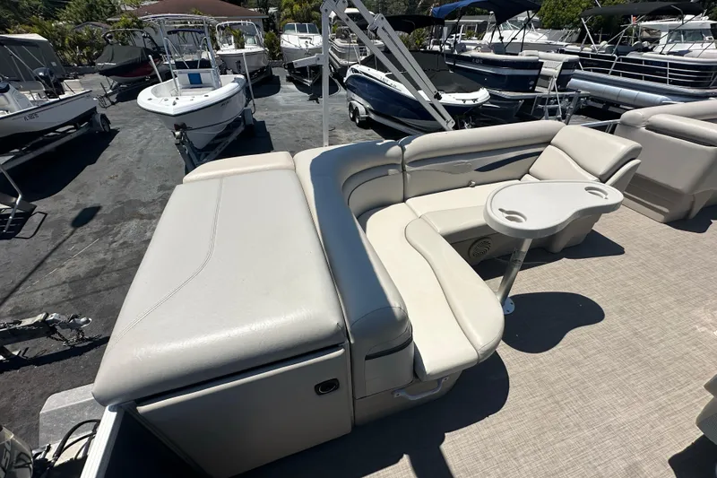 Slide: The Image of 2016 Bennington 21 SX L-Bench pontoon boat with beige seating and cup holders. - 12