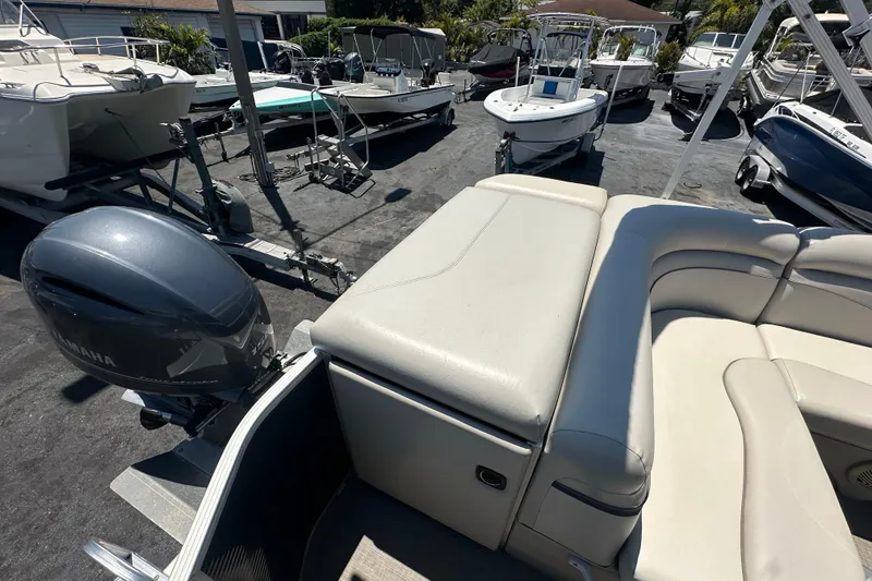 Slide: The Image of 2016 Bennington 21 SX L-Bench pontoon boat with Yamaha motor in a marina. - 13