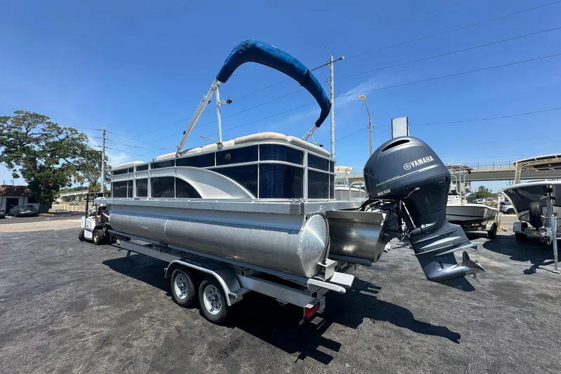 Slide: The Image of 2016 Bennington 21 SX L-Bench pontoon boat with Yamaha outboard motor on trailer. - 2
