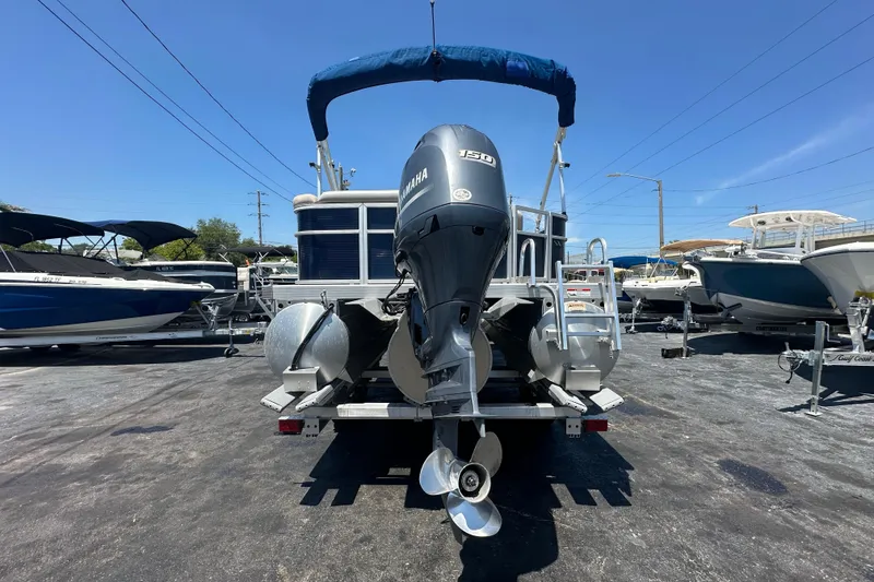 Slide: The Image of 2016 Bennington 21 SX L-Bench pontoon boat with Yamaha outboard motor in a marina. - 3