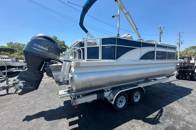 Slide: The Image of 2016 Bennington 21 SX L-Bench pontoon boat with Yamaha outboard motor on trailer. - 4