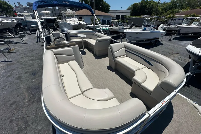 Slide: The Image of 2016 Bennington 21 SX L-Bench pontoon boat with spacious seating in a marina setting. - 6