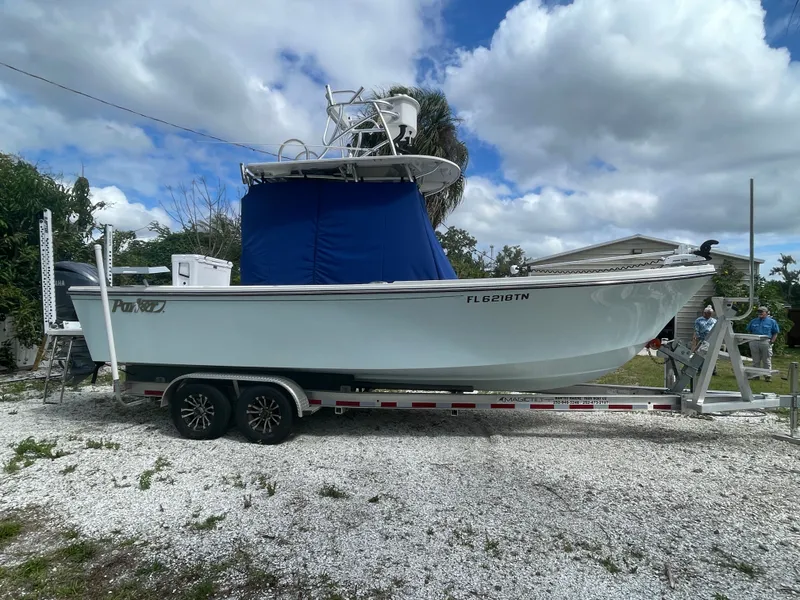 Slide: The Image of Parker 25SE boat 2022 on trailer, blue cover, cloudy sky. - 4