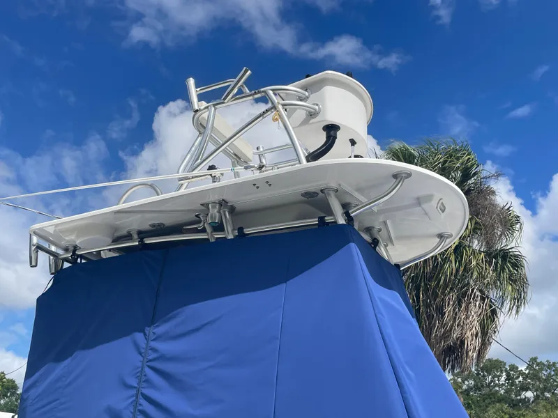 Slide: The Image of Parker 25SE boat 2022 with blue cover and palm trees in background. - 5