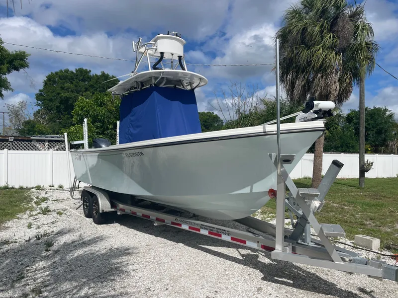 Slide: The Image of Parker 25SE boat 2022 on trailer, blue sky, palm trees. - 6