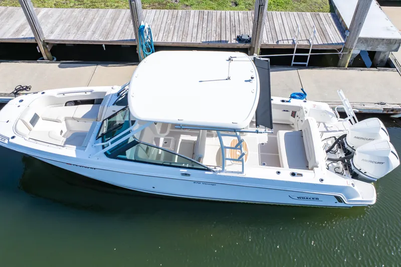 Slide: The Image of 2019 Boston Whaler 270 Vantage boat docked, featuring dual Mercury engines and spacious seating. - 12