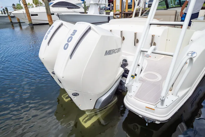 Slide: The Image of 2019 Boston Whaler 270 Vantage with twin Mercury 300 engines docked in marina. - 13