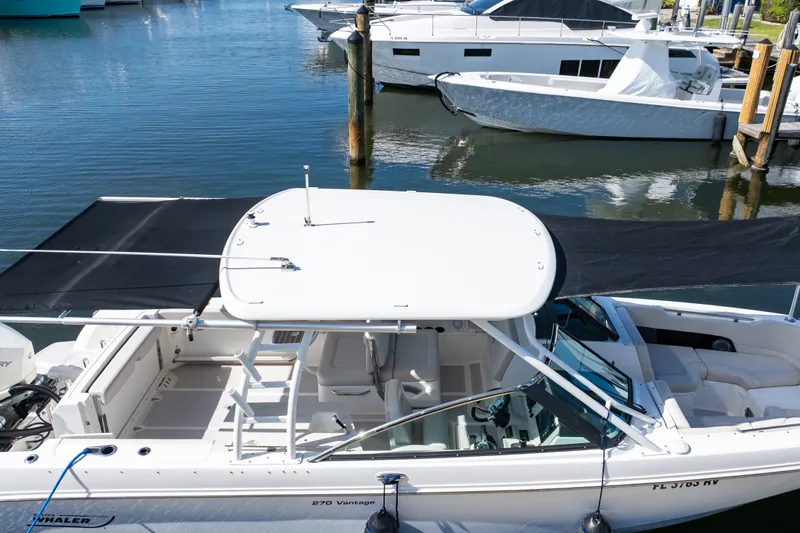 Slide: The Image of 2019 Boston Whaler 270 Vantage boat docked in marina, featuring spacious seating and canopy. - 14