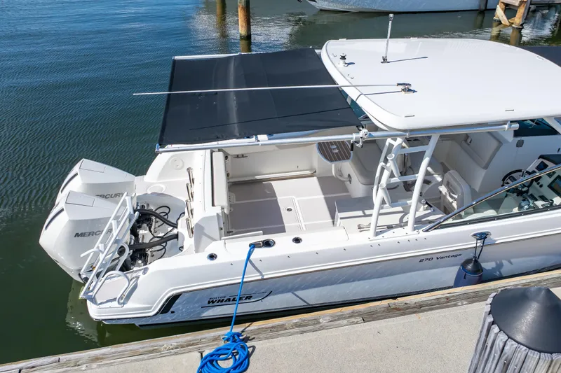 Slide: The Image of 2019 Boston Whaler 270 Vantage boat docked, featuring dual Mercury engines. - 16