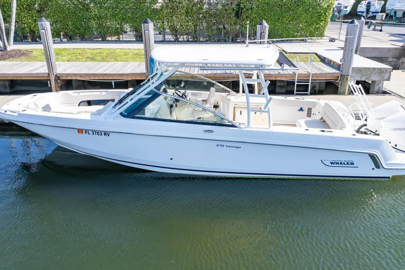 Slide: The Image of 2019 Boston Whaler 270 Vantage boat docked in calm waters. - 17