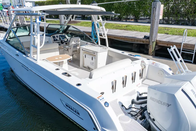 Slide: The Image of 2019 Boston Whaler 270 Vantage boat docked, featuring spacious seating and dual Mercury engines. - 18