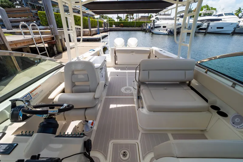 Slide: The Image of 2019 Boston Whaler 270 Vantage boat interior with seating and steering wheel, docked at marina. - 3