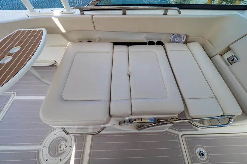 Slide: The Image of 2019 Boston Whaler 270 Vantage interior with cushioned seating and wooden table. - 41
