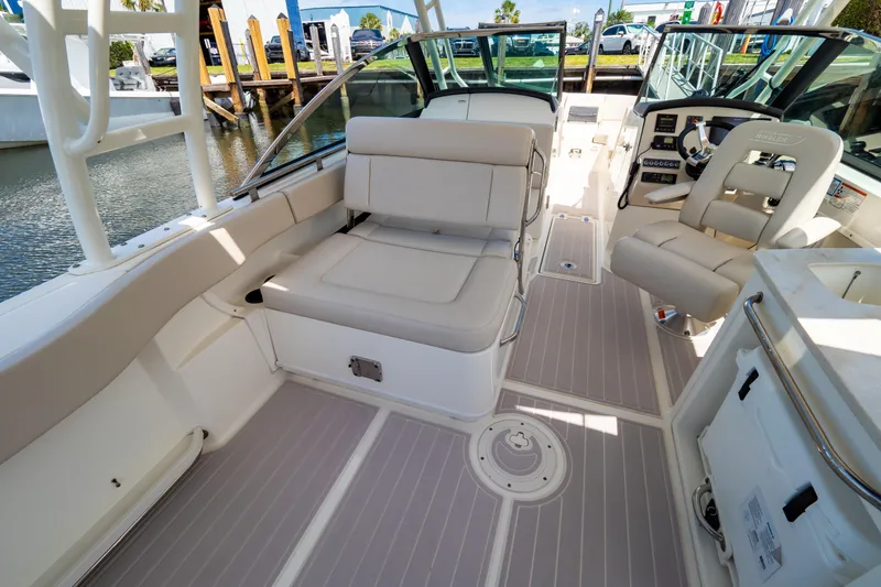Slide: The Image of 2019 Boston Whaler 270 Vantage boat interior with seating and helm, docked by the water. - 44
