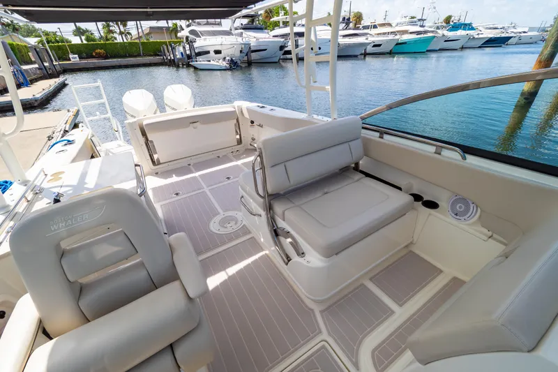 Slide: The Image of 2019 Boston Whaler 270 Vantage boat interior with seating, docked near other yachts. - 65