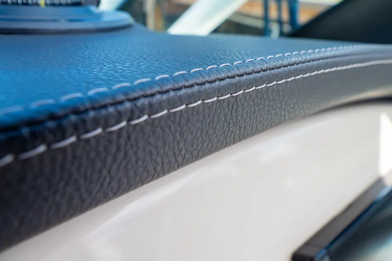 Slide: The Image of Close-up of 2019 Boston Whaler 270 Vantage's detailed leather stitching on dashboard. - 67