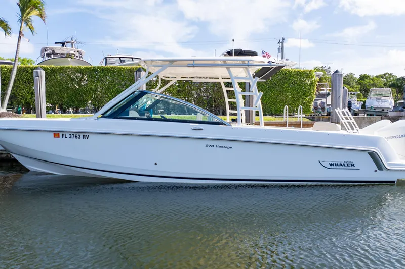 Slide: The Image of 2019 Boston Whaler 270 Vantage boat docked in a marina under clear skies. - 69