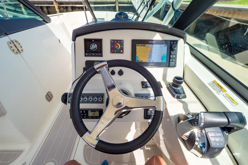 Slide: The Image of 2019 Boston Whaler 270 Vantage helm with steering wheel, navigation screens, and controls. - 70