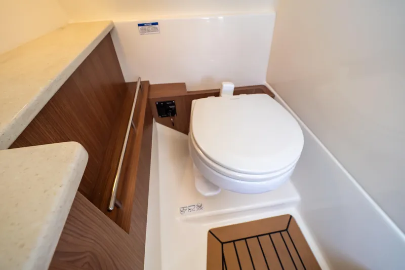 Slide: The Image of 2019 Boston Whaler 270 Vantage boat bathroom with toilet and wooden accents. - 78