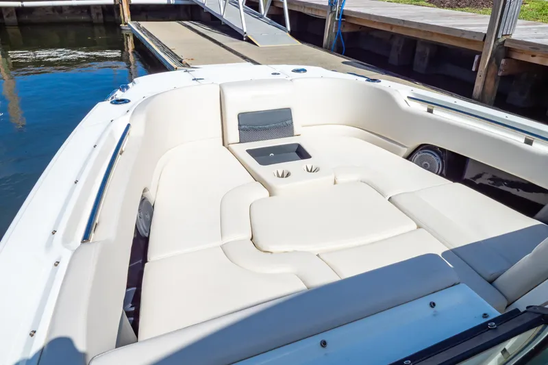 Slide: The Image of 2019 Boston Whaler 270 Vantage boat interior with cushioned seating and cup holders at dock. - 91