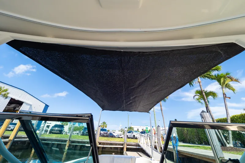 Slide: The Image of 2019 Boston Whaler 270 Vantage boat with sunshade, docked under clear blue sky. - 94