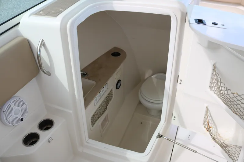 Slide: The Image of 2020 Sailfish 275 DC boat interior with compact bathroom and storage features. - 12